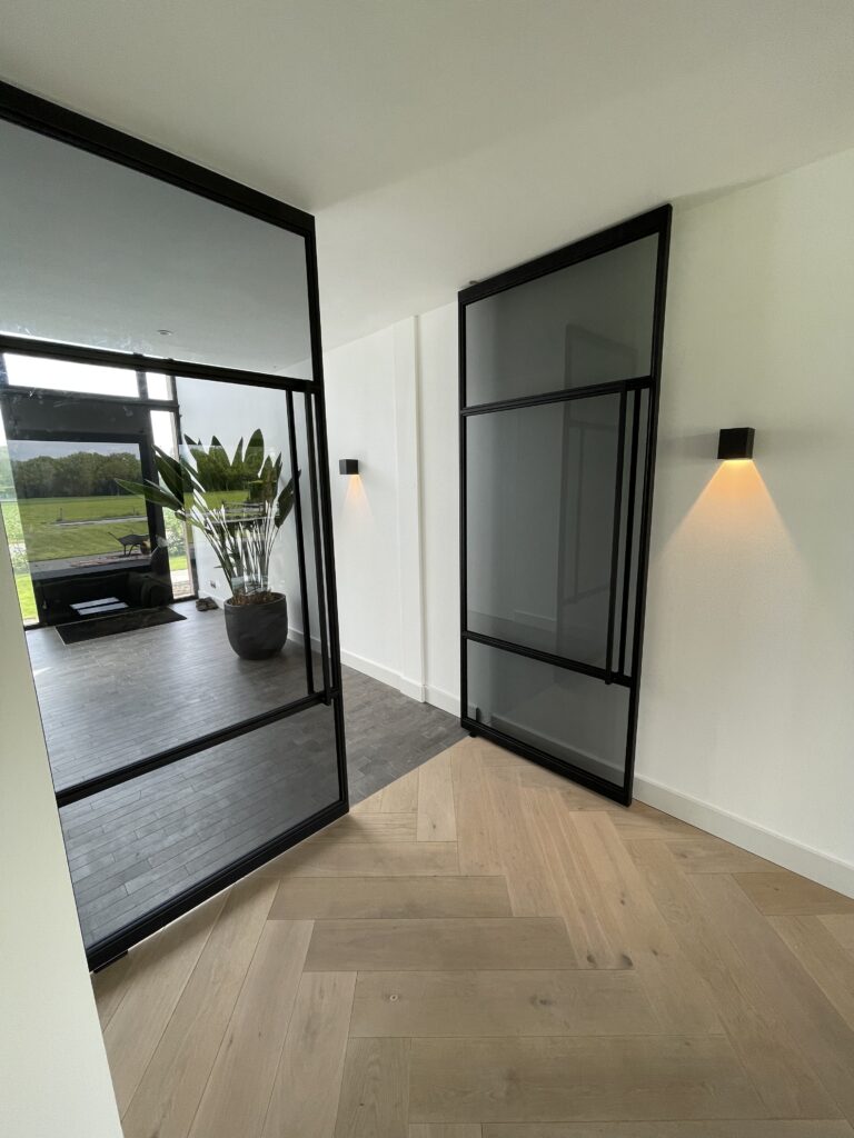 Dubbele taatsdeur met glazen panelen voor woningen met industriële uitstraling